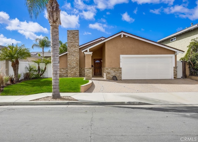 view of front of house featuring stucco siding, a front lawn, a garage, stone siding, and decorative driveway