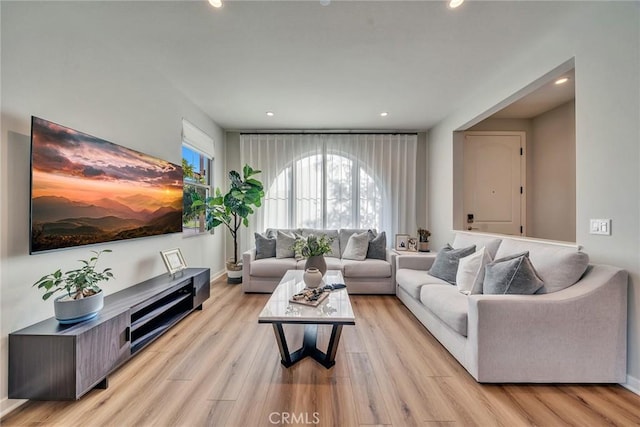 living room featuring light wood finished floors, recessed lighting, and baseboards