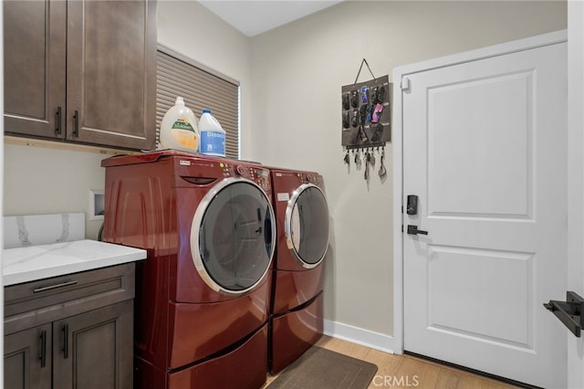 10983 Redwood Ave, Hesperia, CA 92345 - washroom with cabinet space, washer and clothes dryer, light wood-style flooring, and baseboards