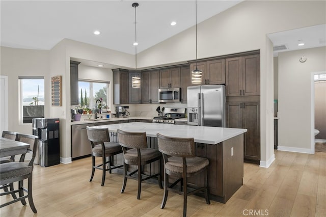 10983 Redwood Ave, Hesperia, CA 92345 - kitchen with stainless steel appliances, a sink, dark brown cabinetry, light countertops, and light wood finished floors