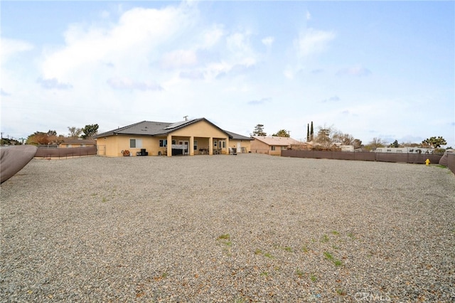 10983 Redwood Ave, Hesperia, CA 92345 - rear view of house featuring roof mounted solar panels and a fenced backyard