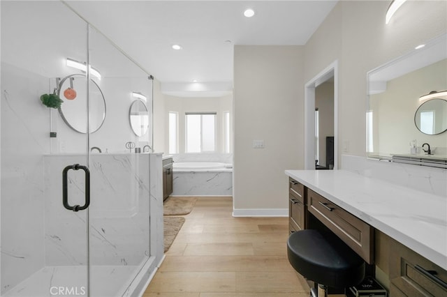 10983 Redwood Ave, Hesperia, CA 92345 - bathroom with a marble finish shower, wood finished floors, a garden tub, recessed lighting, and vanity