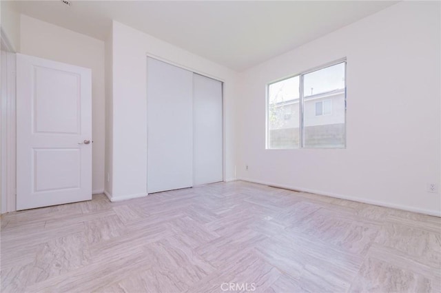 unfurnished bedroom featuring a closet and baseboards