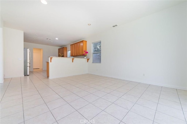 unfurnished living room with light tile patterned floors, visible vents, and recessed lighting