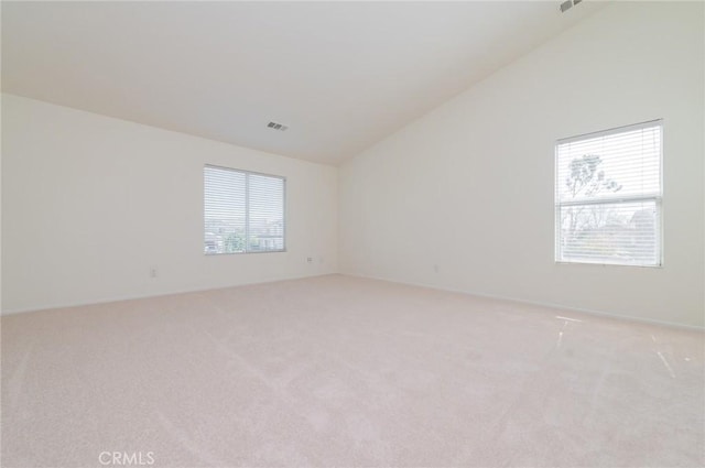 unfurnished room with light carpet, visible vents, and lofted ceiling