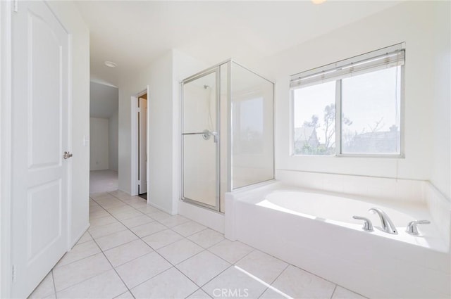 bathroom featuring tile patterned flooring, a shower stall, and a garden tub