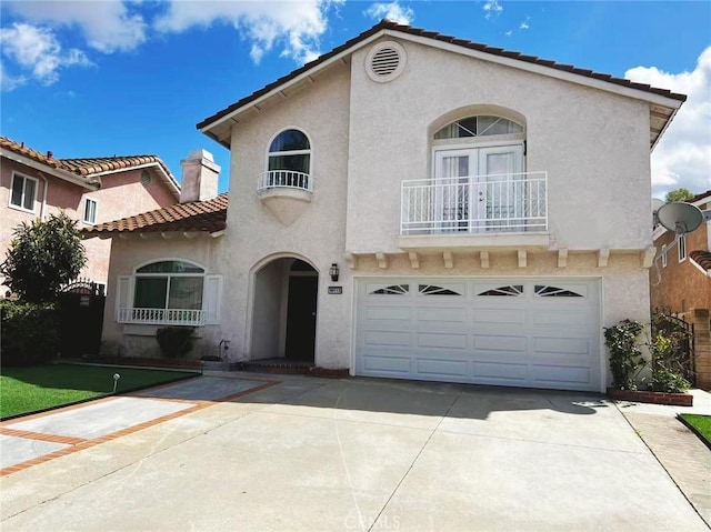 mediterranean / spanish-style house featuring concrete driveway, a tile roof, stucco siding, a chimney, and an attached garage