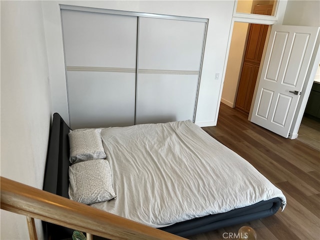 bedroom with wood finished floors and a closet