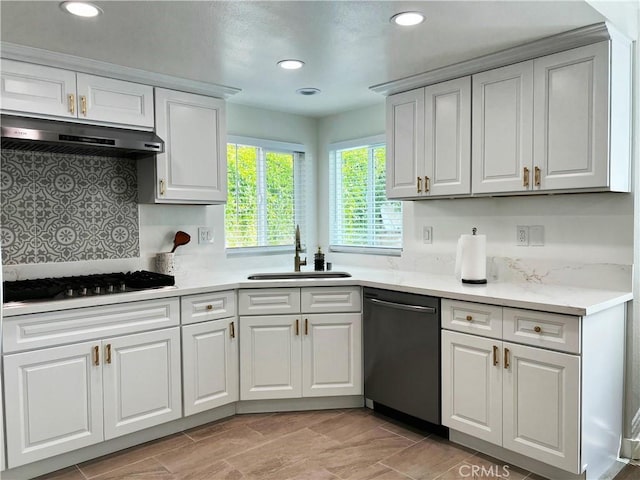 kitchen featuring under cabinet range hood, light countertops, dishwashing machine, gas stovetop, and a sink