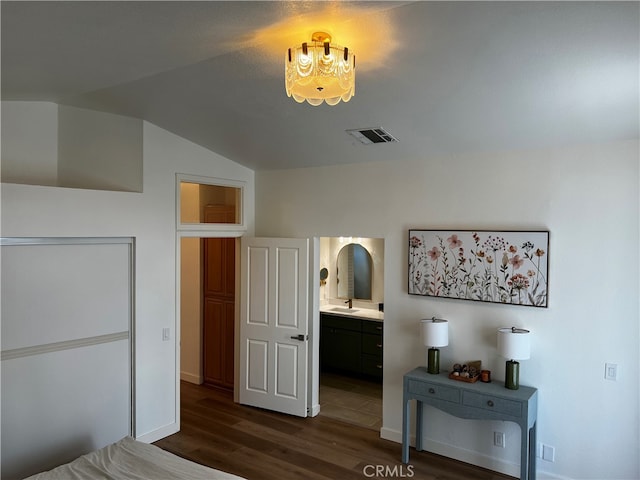 bedroom with visible vents, dark wood-type flooring, a sink, baseboards, and vaulted ceiling