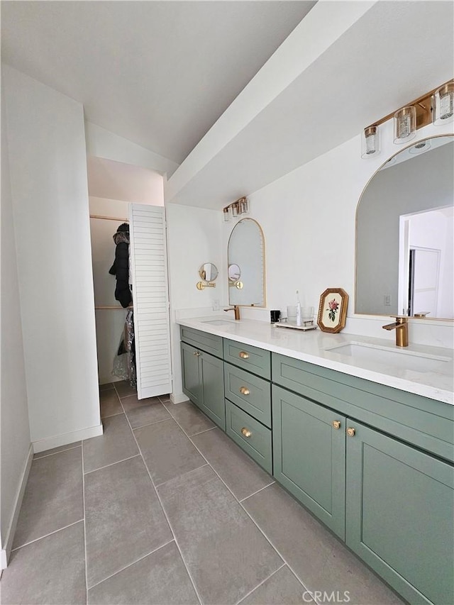 bathroom with a sink, lofted ceiling, double vanity, and tile patterned flooring