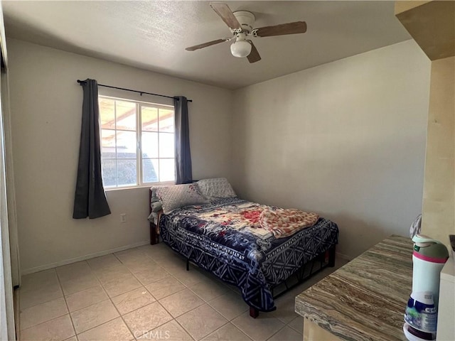 bedroom with light tile patterned flooring, baseboards, and a ceiling fan