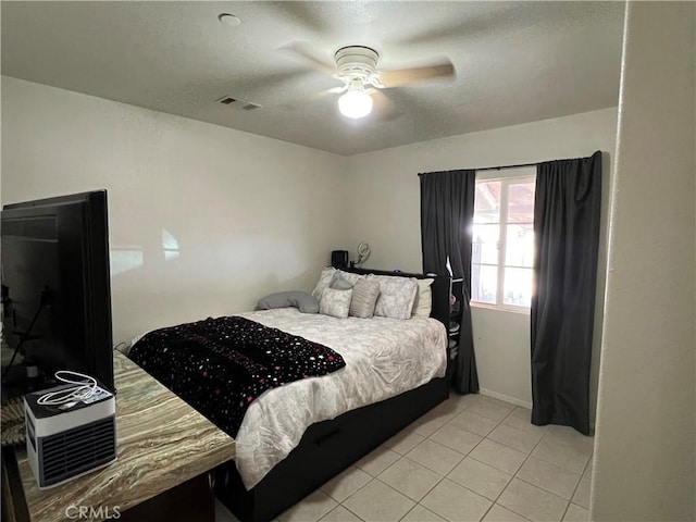 bedroom with visible vents, light tile patterned flooring, and a ceiling fan