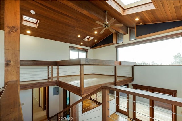 hall featuring recessed lighting, lofted ceiling with skylight, wood ceiling, and an upstairs landing