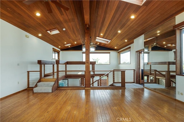 interior space with baseboards, ceiling fan, hardwood / wood-style flooring, wood ceiling, and lofted ceiling with skylight