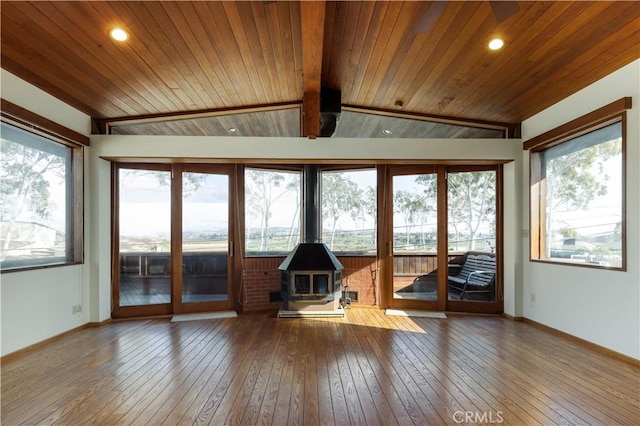 unfurnished sunroom with lofted ceiling, wooden ceiling, and a wood stove