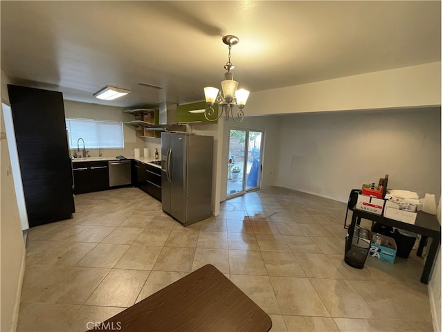 kitchen with a chandelier, light countertops, hanging light fixtures, stainless steel appliances, and a sink