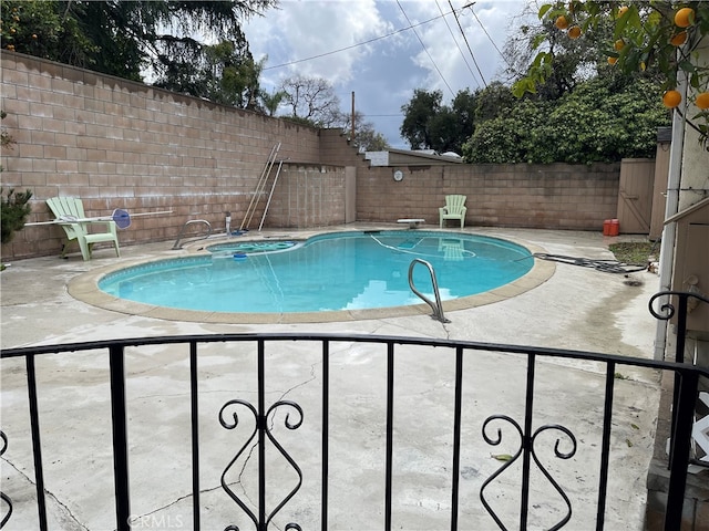 view of pool featuring a patio area, a diving board, a fenced backyard, and a fenced in pool