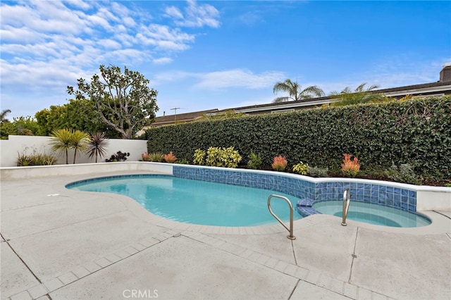 view of swimming pool with a patio, a fenced in pool, a fenced backyard, and an in ground hot tub
