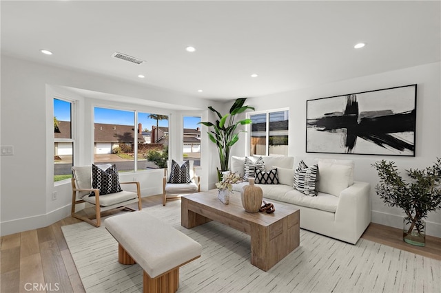 living room with recessed lighting, light wood-style flooring, baseboards, and visible vents