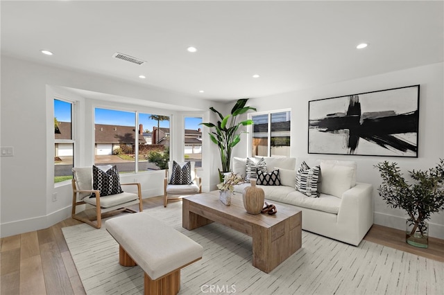 living room with baseboards, visible vents, light wood-style floors, and recessed lighting