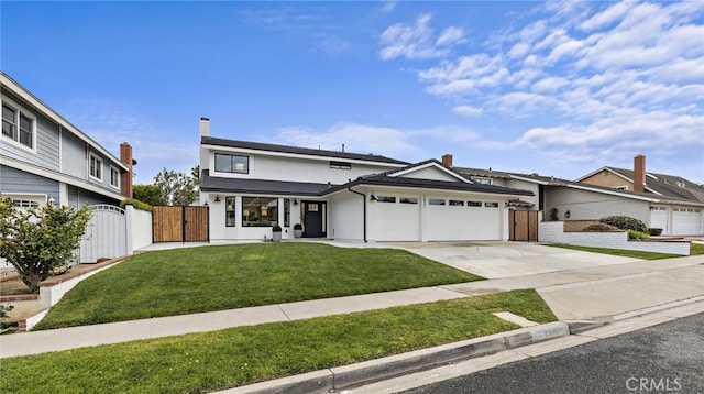 traditional-style house featuring concrete driveway, a gate, a front yard, fence, and a garage