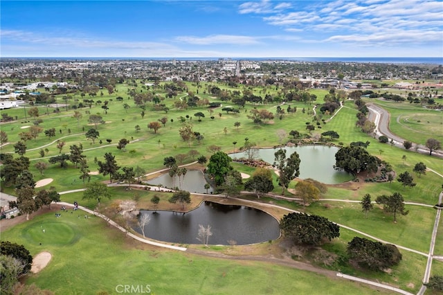 drone / aerial view with golf course view and a water view