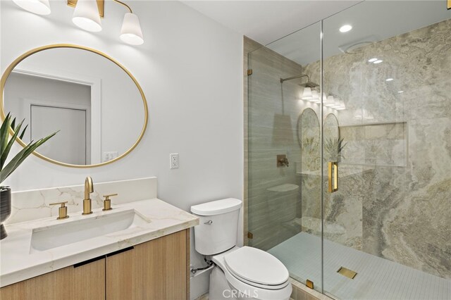 full bathroom featuring vanity, a shower stall, and toilet