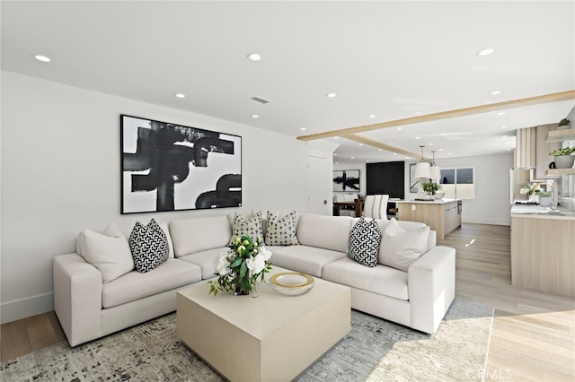 living room with visible vents, recessed lighting, light wood-style floors, and baseboards