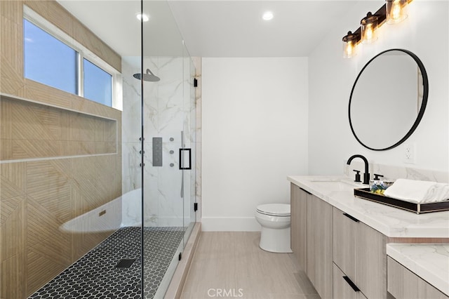 full bath featuring a marble finish shower, baseboards, toilet, recessed lighting, and vanity