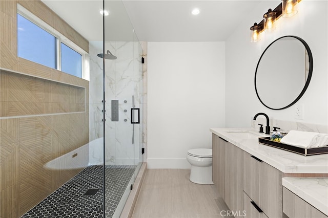 bathroom featuring baseboards, a marble finish shower, toilet, recessed lighting, and vanity