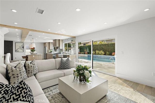 living area featuring light wood finished floors, recessed lighting, visible vents, and baseboards