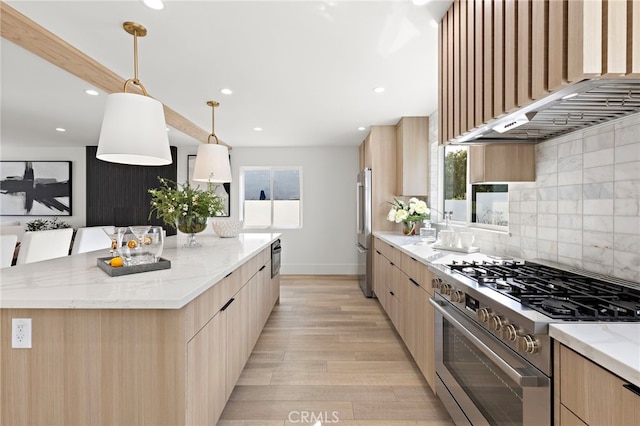 kitchen with light brown cabinets, appliances with stainless steel finishes, and modern cabinets