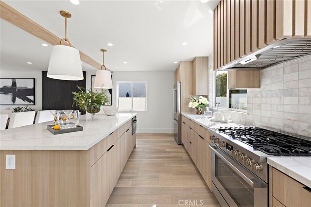 kitchen with appliances with stainless steel finishes, modern cabinets, and light brown cabinetry