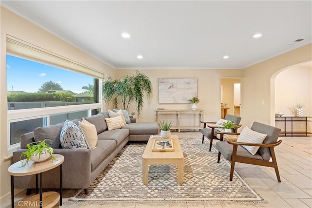 living area with arched walkways, recessed lighting, and ornamental molding