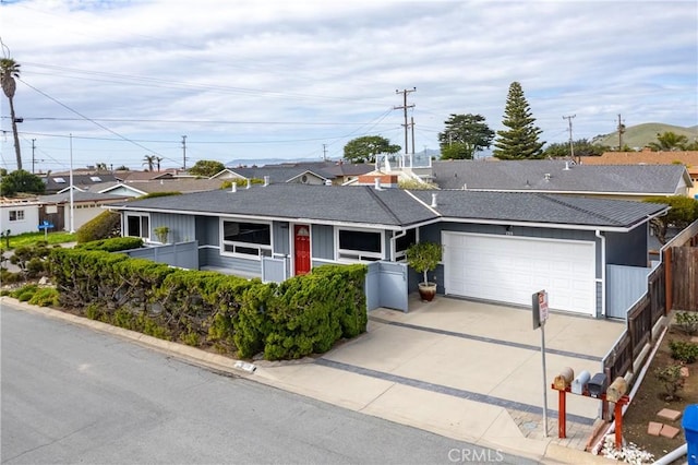 ranch-style home featuring an attached garage, fence, and driveway