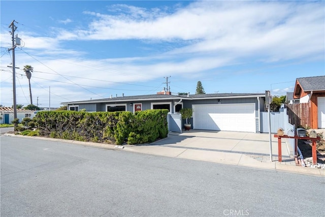 ranch-style home featuring concrete driveway, an attached garage, and fence