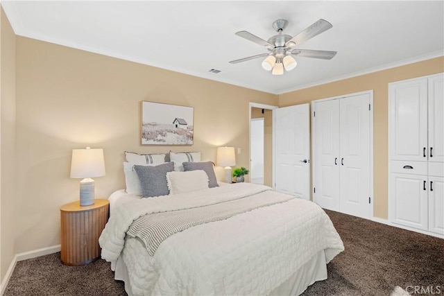 bedroom with visible vents, crown molding, baseboards, multiple closets, and dark carpet