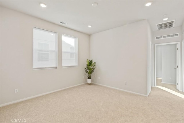 spare room with recessed lighting, visible vents, and light carpet