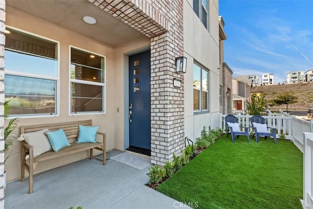 entrance to property featuring a yard and stucco siding