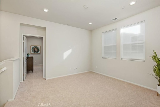 spare room with recessed lighting, visible vents, baseboards, and light colored carpet