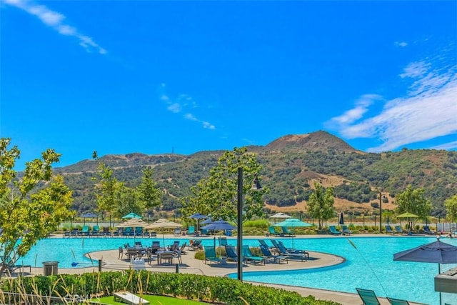 pool featuring a patio, fence, and a mountain view