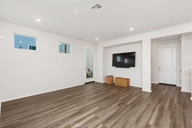 unfurnished living room with recessed lighting, wood finished floors, visible vents, and baseboards