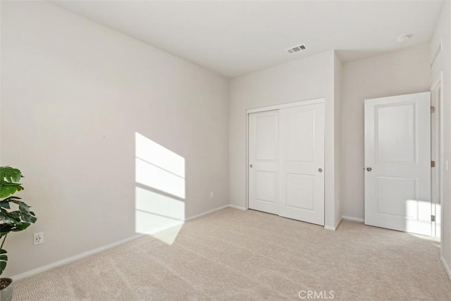 unfurnished bedroom featuring a closet, baseboards, visible vents, and carpet flooring