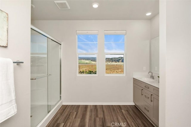 full bath featuring visible vents, vanity, wood finished floors, and a shower stall