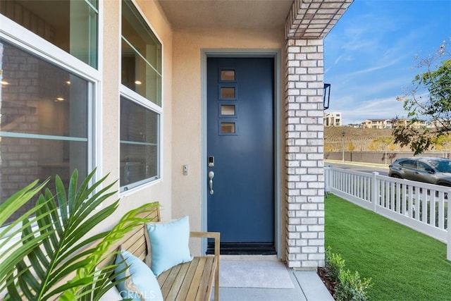 doorway to property with brick siding and stucco siding