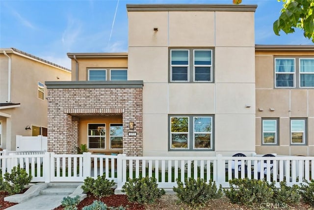 multi unit property featuring a fenced front yard and stucco siding