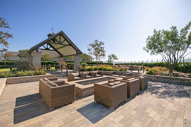 view of patio with an outdoor living space with a fire pit