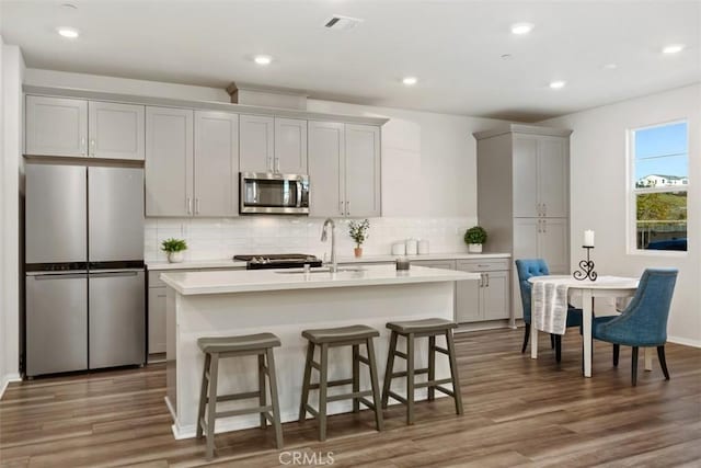 kitchen featuring tasteful backsplash, appliances with stainless steel finishes, and wood finished floors