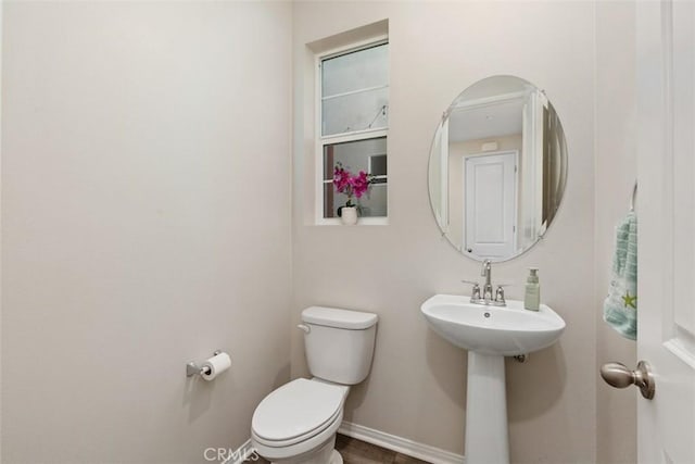 bathroom featuring toilet and baseboards